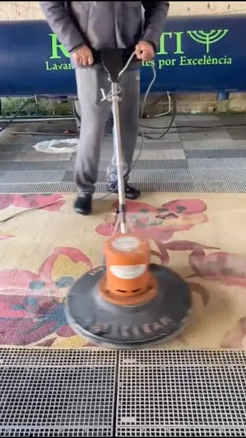 Profissional da Riganti operando máquina de limpeza sobre um tapete floral